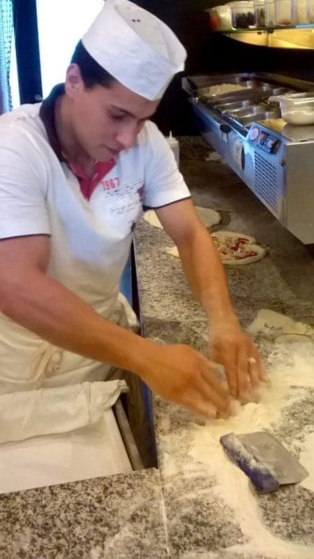 Her kan du se at han bare bruker fingertuppene for å utvide pizzaen, forte raske bevegelser, da vil den ikke "skrumpe inn igjen"